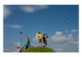 Kids on rounded hill, clouds and seagulls